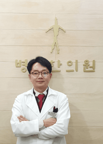 병인한의원 죽곡점 김경신 대표원장이 원내 간판 앞에 흰 가운을 입고 서 있는 모습